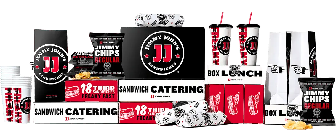 An assortment of Jimmy John's catering products, featuring sandwich boxes, drink cups, chip bags, and wrapped sandwiches, arranged neatly by the renowned sandwich franchise.